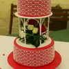 Hochzeitstorte in rot mit weißer Herzchenspitze und echten Blumen